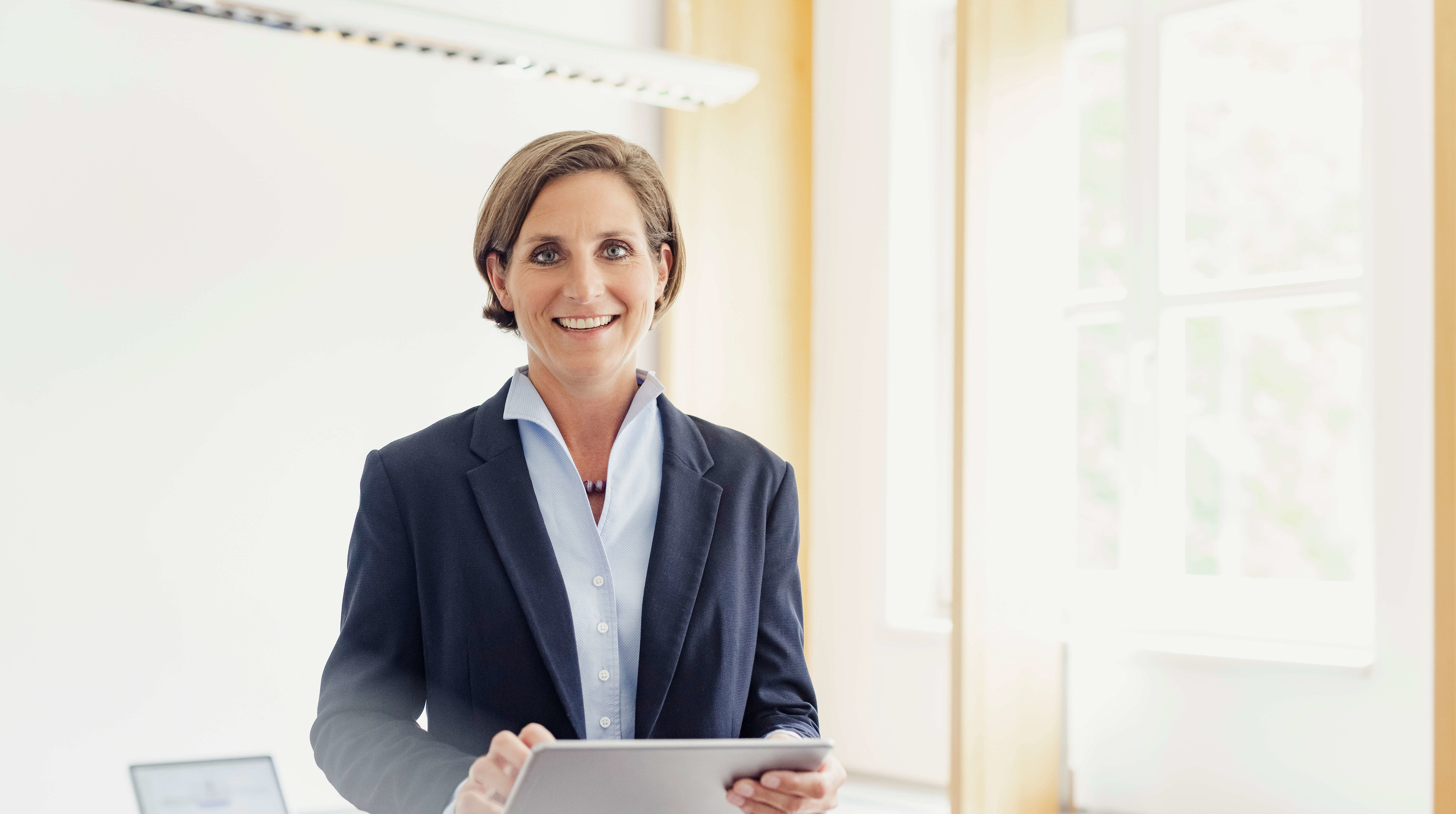 Mitarbeiterin der Alpen Privatbank mit Tablet in der Hand